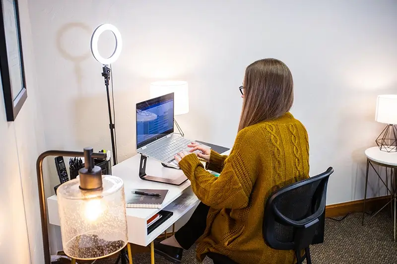 on-demand-CE-trainings A therapist at her laptop in her office